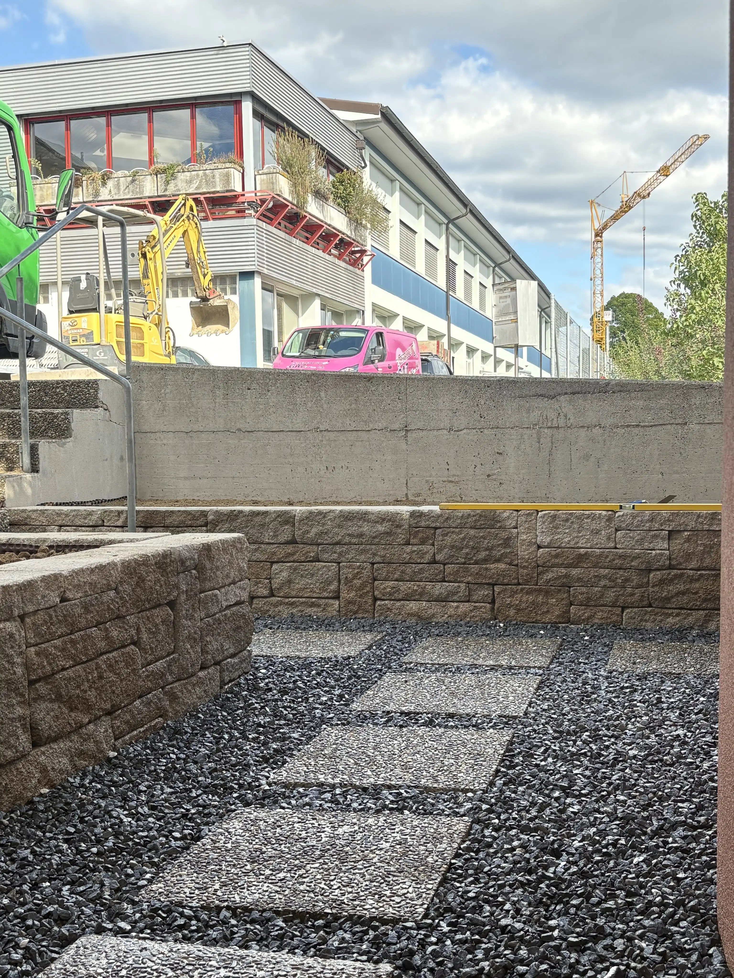 Le chantier : murets en blocs de pierre et pas en dalles posés dans le gravier gris