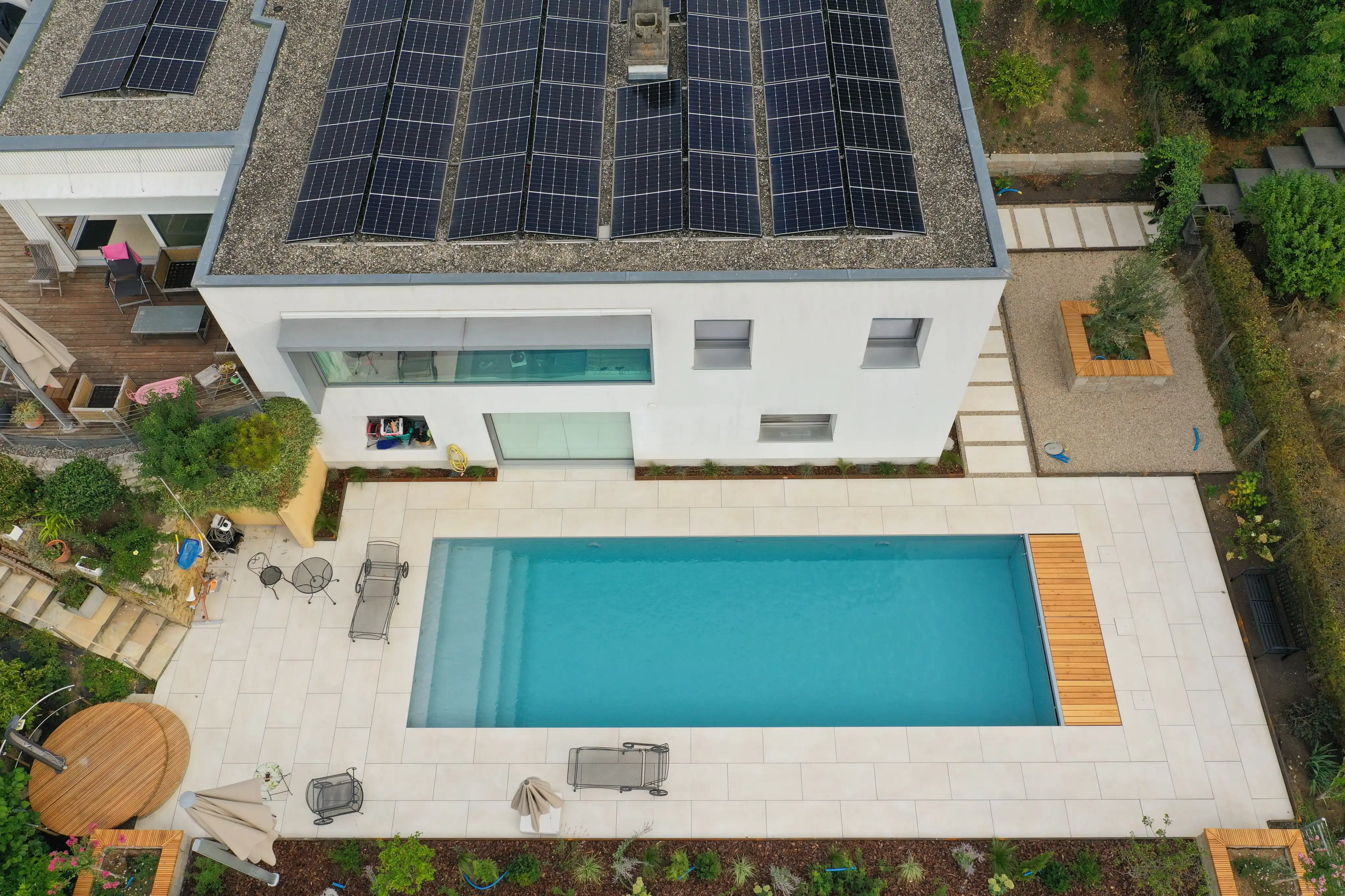 Vue aérienne du jardin : la maison, la piscine, les plates-bandes et les bacs plantés